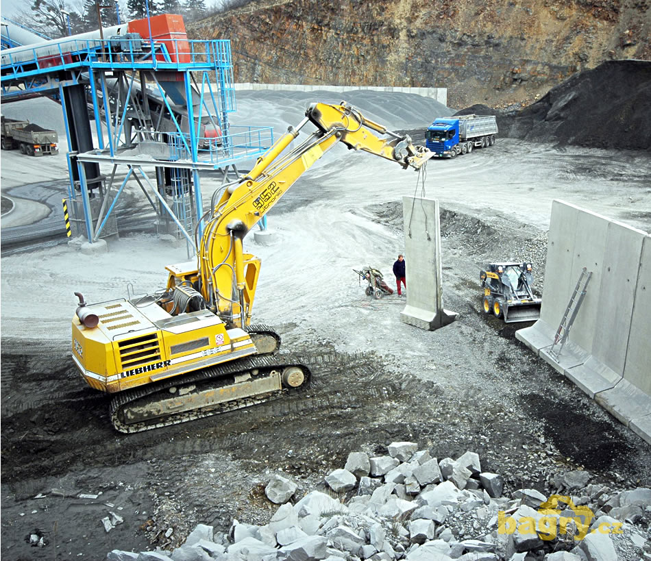 Liebherr R 952 Litronic a New Holland LS150 budují prefabrikovanou stěnu mezi boxy