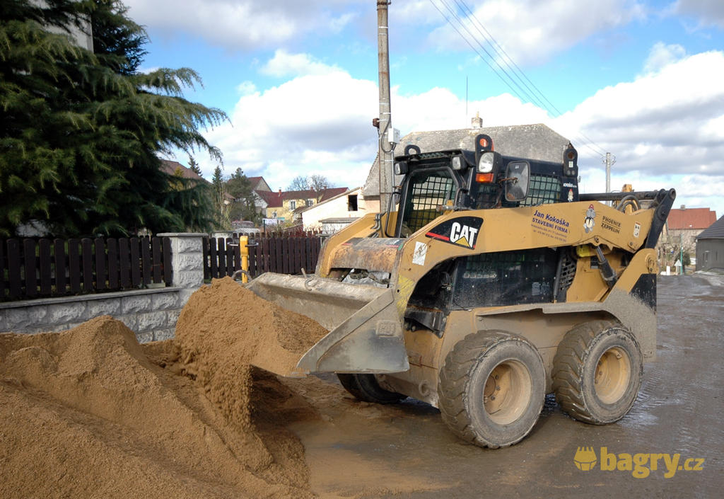 Kolový nakladač Caterpillar 246B nabírá materiál