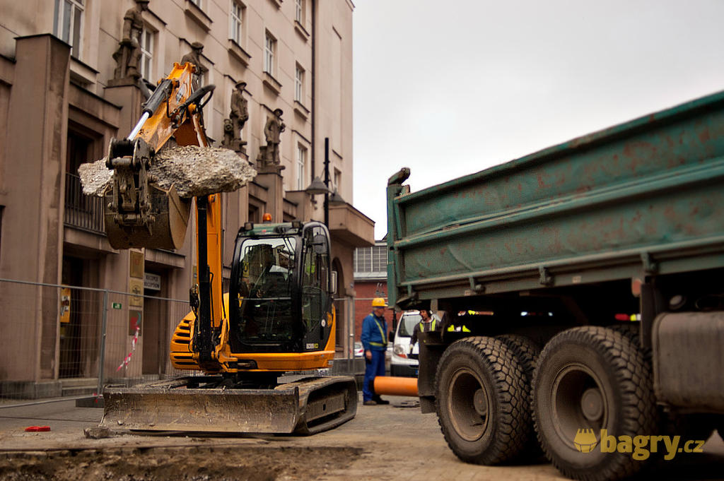 Pásové midirypadlo JCB 8085 ZTS firmy Demontstav s kusem betonu ve lžíci