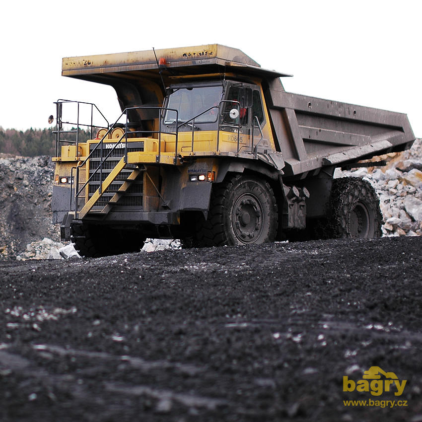 Pevný dempr Komatsu HD605-5 s trakčními řetězy Pewag Compact Cross 14