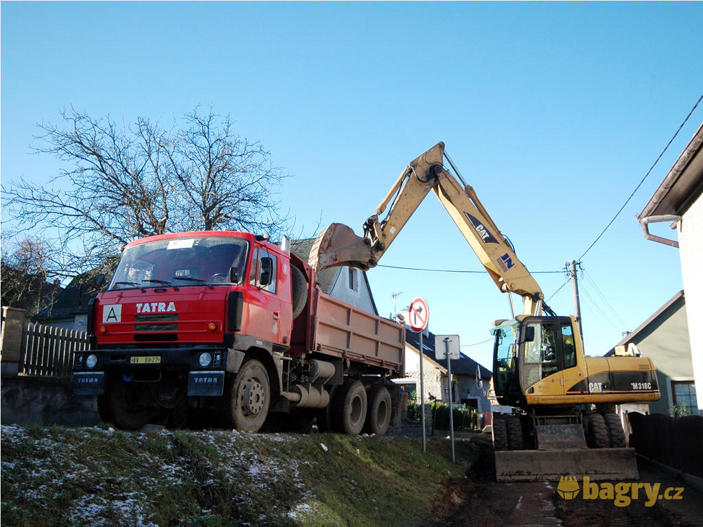 Kolové rypadlo Caterpillar M318C nakládá Tatru T-815