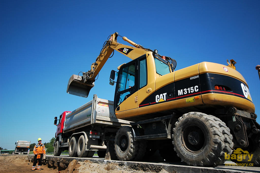 Kolové rypadlo Caterpillar M315C nakládá na auto