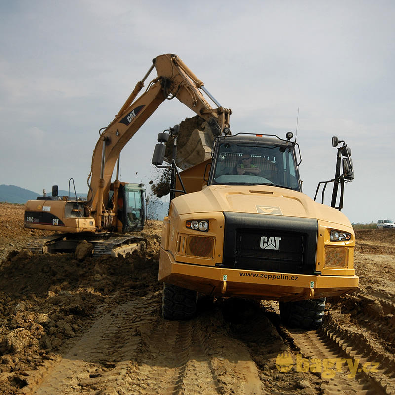 Kloubový dempr Caterpillar 730C2 nakládaný rypadlem Caterpillar 325C LNME