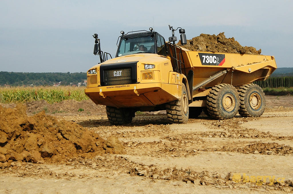 Kloubový dempr Caterpillar 730C2 přijíždí k deponii