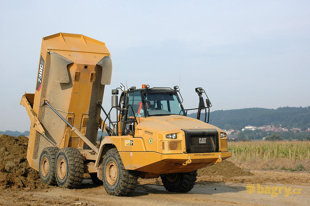 Kloubový dempr Caterpillar 730C2 vyklopil zeminu
