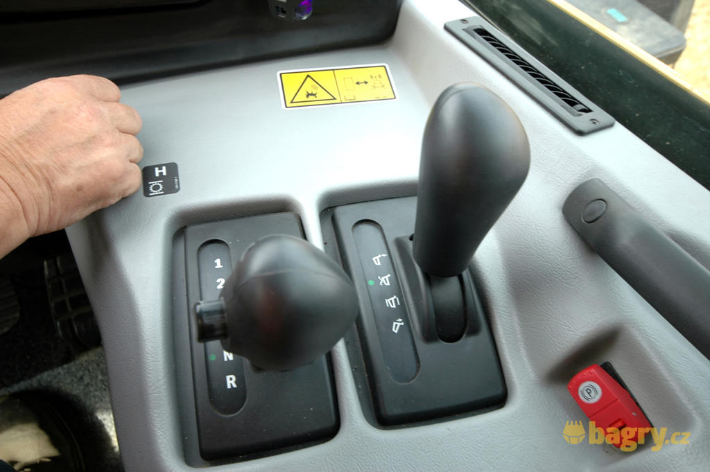 Vlevo páka automatické převodovky, vpravo páka sklápění korby