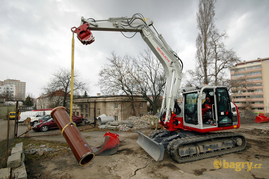 09. Takeuchi TB2150 manipuluje s kameninovým potrubím