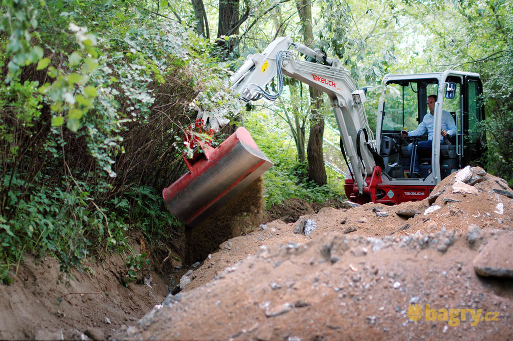 Takeuchi TB240 zasýpá rýhu kolem cesty