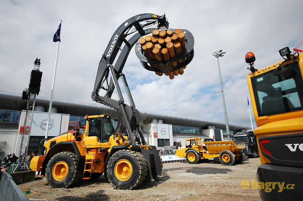 Kolový nakladač Volvo L180H s drapákem na kulatinu.